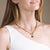 Woman wearing gold plated curb chain necklace with constellation astrology pendant